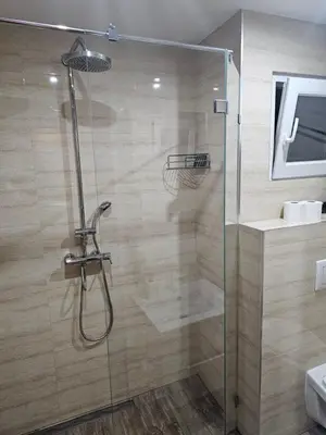 a bathroom with a shower with a glass door at Central Park Rooms in Belgrade