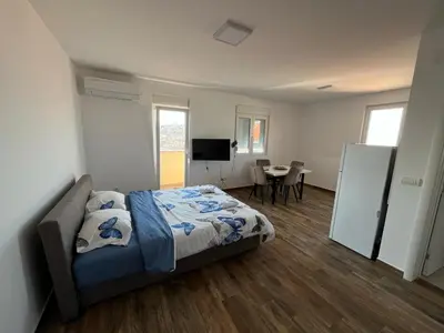 a bedroom with a bed and a table in it at Mimura stan 2 in Belgrade
