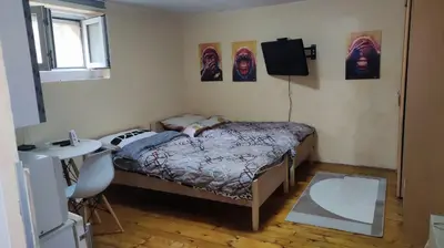 a bedroom with a bed and a table and a sink at Goxy flat in Belgrade