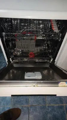 an open dishwasher with a cell phone inside of it at Goxy flat in Belgrade
