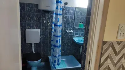 a bathroom with a blue shower curtain and a sink at Goxy flat in Belgrade
