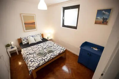a small bedroom with a bed and a blue cabinet at Tiny apartment in Belgrade