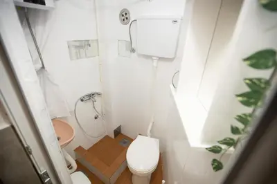 a small bathroom with a toilet and a shower at Tiny apartment in Belgrade
