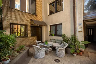 a patio with a bench and chairs and a table at Tiny apartment in Belgrade
