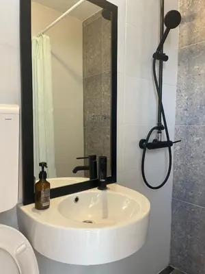 a bathroom with a white sink and a shower at Belgrade Panoramic View Large Terrace Free Parking in Belgrade