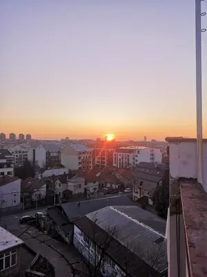 a view of a city with the sunset in the background at Belgrade Panoramic View Large Terrace Free Parking in Belgrade