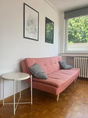 a living room with a pink couch and a table at Belgrade Panoramic View Large Terrace Free Parking in Belgrade