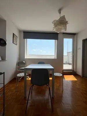 a dining room with a table and chairs and a window at Belgrade Panoramic View Large Terrace Free Parking in Belgrade