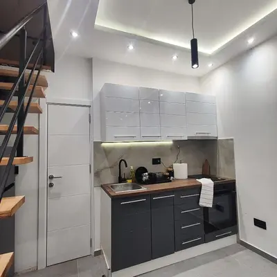 a kitchen with white cabinets and a sink at Zeus Apartment in Rakovica