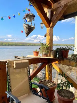 a porch with a table and chairs and a view of the water at Bird of Paradise in Belgrade