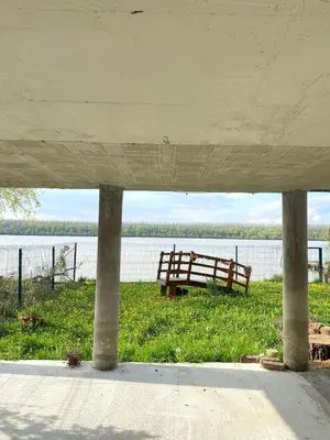 a bench sitting in the grass next to a body of water at Bird of Paradise in Belgrade