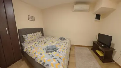 a small bedroom with a bed and a television at Center Point apartment in Belgrade