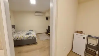 a small bedroom with a bed and a small refrigerator at Center Point apartment in Belgrade