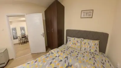 a bedroom with a bed and a door to a dining room at Center Point apartment in Belgrade
