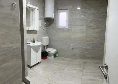a bathroom with a white toilet and a sink at Airport Art Villa in Čukarica
