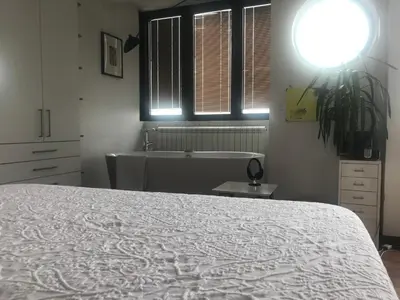 a bedroom with a bed and a tub and a window at Exceptional City Center River View Apartment in Belgrade