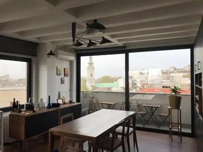 a dining room with a table and a large window at Exceptional City Center River View Apartment in Belgrade