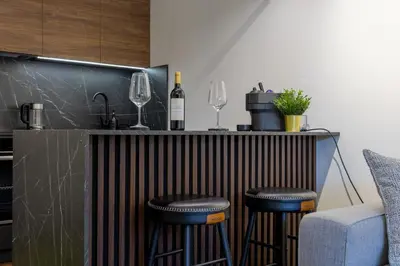 a bar with two wine glasses and two stools at Deluxe Kosmaj Residence in Rogača