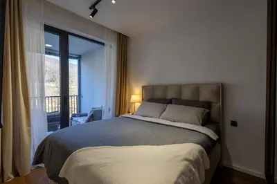a bedroom with a large bed and a large window at Deluxe Kosmaj Residence in Rogača