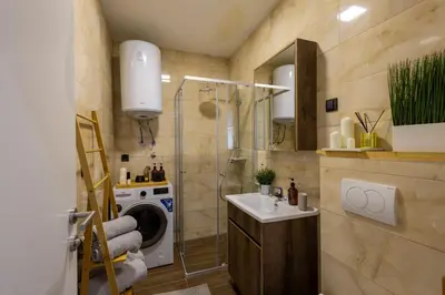 a bathroom with a sink and a washing machine at Deluxe Kosmaj Residence in Rogača