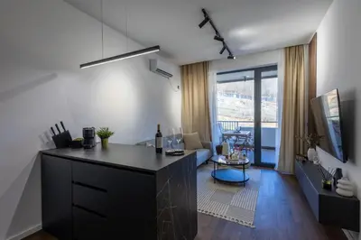 a kitchen with a counter and a living room at Deluxe Kosmaj Residence in Rogača