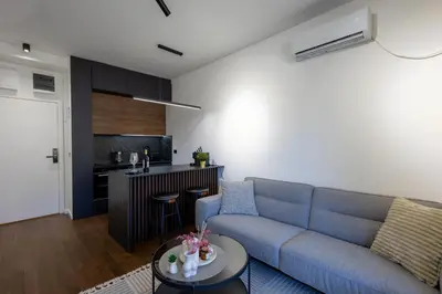 a living room with a blue couch and a kitchen at Deluxe Kosmaj Residence in Rogača