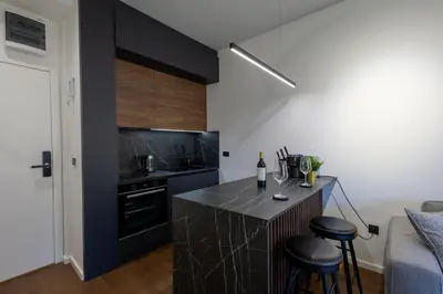 a kitchen with black cabinets and a counter with stools at Deluxe Kosmaj Residence in Rogača