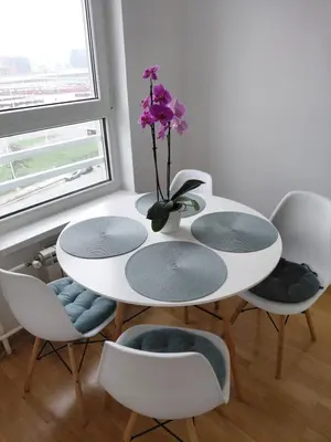 a table with four chairs and a vase with purple flowers at Premium Belvil apartment, free parking in Belgrade