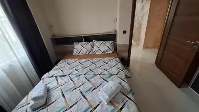a bedroom with a bed with a comforter on it at Apartman Laki-M in Belgrade