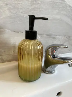 a gold soap dispenser sitting on top of a sink at Airport Art Villa in Ćosine Kolibe