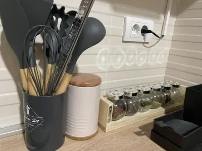 a cup filled with utensils next to a rack of spices at Stylish and cozy stay in Belgrade