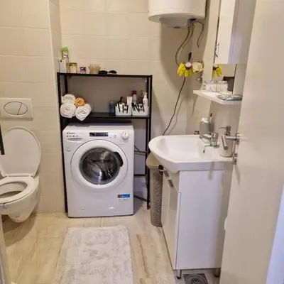 a bathroom with a washing machine and a sink at Stylish and cozy stay in Belgrade