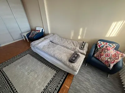 a room with a bed and a chair and a rug at Comfort & Style Panoramic Urban Retreat 2 in Belgrade