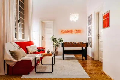 a living room with a red couch and a table at Inspiration Source with Balcony Old Town in Belgrade