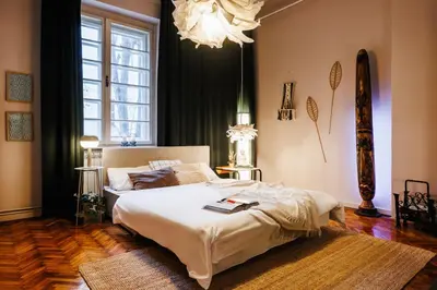 a bedroom with a large bed and a chandelier at Inspiration Source with Balcony Old Town in Belgrade