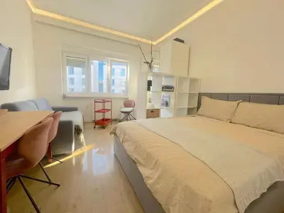 a bedroom with a bed and a table and a desk at Hilton View Cozy Njegoseva Vracar Apartment - Sleeps 4 in Belgrade