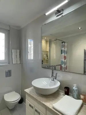 a bathroom with a sink and a toilet and a mirror at Hilton View Cozy Njegoseva Vracar Apartment - Sleeps 4 in Belgrade