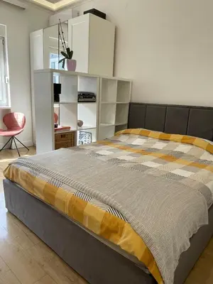 a bedroom with a bed and a red chair at Hilton View Cozy Njegoseva Vracar Apartment - Sleeps 4 in Belgrade