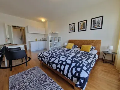 a bedroom with a large bed and a kitchen at Apartman Fox in Belgrade