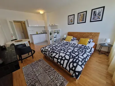 a bedroom with a bed with a black and white blanket at Apartman Fox in Belgrade