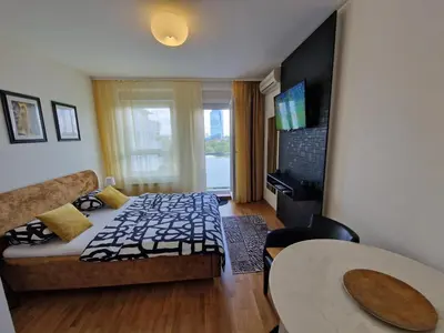 a living room with a bed and a table at Apartman Fox in Belgrade