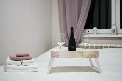 a table with a bottle of wine and two glasses at Sorelle in Belgrade