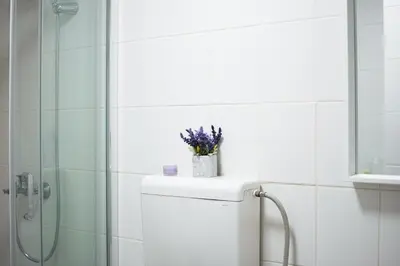 a bathroom with a shower and a toilet with flowers on it at Sorelle in Belgrade