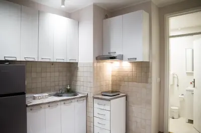 a white kitchen with a sink and a refrigerator at Sorelle in Belgrade