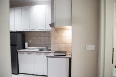 a kitchen with white cabinets and a sink at Sorelle in Belgrade