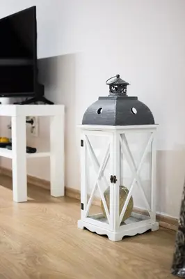 a white lantern with a black top on the floor at Sorelle in Belgrade