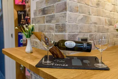 a bottle of wine and two glasses on a counter at Skadarlija Aurora in Belgrade
