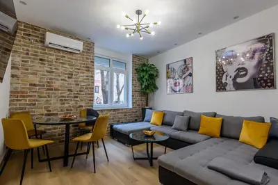 a living room with a couch and a brick wall at Skadarlija Aurora in Belgrade