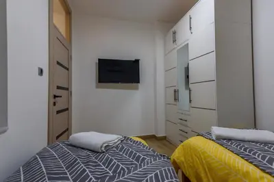 a bedroom with two beds and a tv on the wall at Skadarlija Aurora in Belgrade