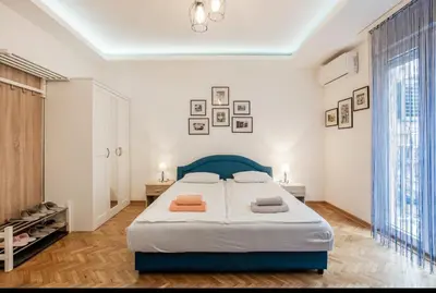 a bedroom with a large bed with a blue headboard at Balkan-inn Apartment Terazije 2 in Belgrade